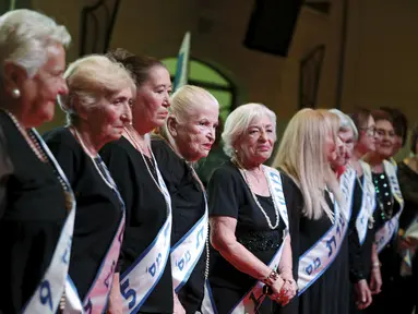 Para peserta berdiri di atas panggung saat mengikuti kontes kecantikan Miss Holocaust Survivor di Israel, Selasa (24/11). 13 wanita lansia mengikuti kontes kecantikan tahun ketiga yang diperuntukkan bagi korban selamat genosida Nazi. (REUTERS/Amir Cohen)
