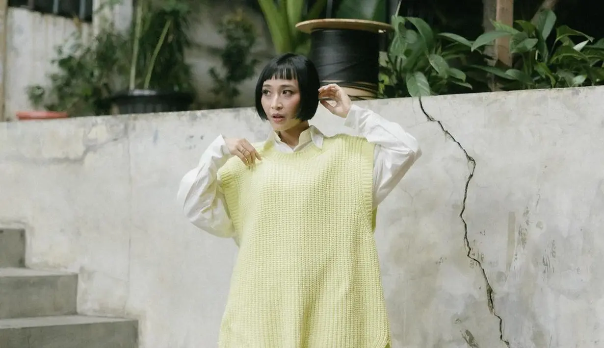 Padu padan kemeja putih, knit vest, dan sepatu boots krem bikin penampilan kasual Rinni terlihat semakin menarik. [Instagram/rinni_w].