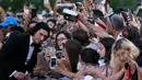 Adam Driver berpose untuk foto selfie saat ia tiba untuk Upacara Pembukaan dan pemutaran film "White Noise" (31/8/2022) selama Festival Film Internasional Venesia ke-79 di Lido di Venezia di Venesia, Italia. Adam melayani ajakan foto selfie penggemar sebanyak mungkin. (Tiziana FABI/AFP)