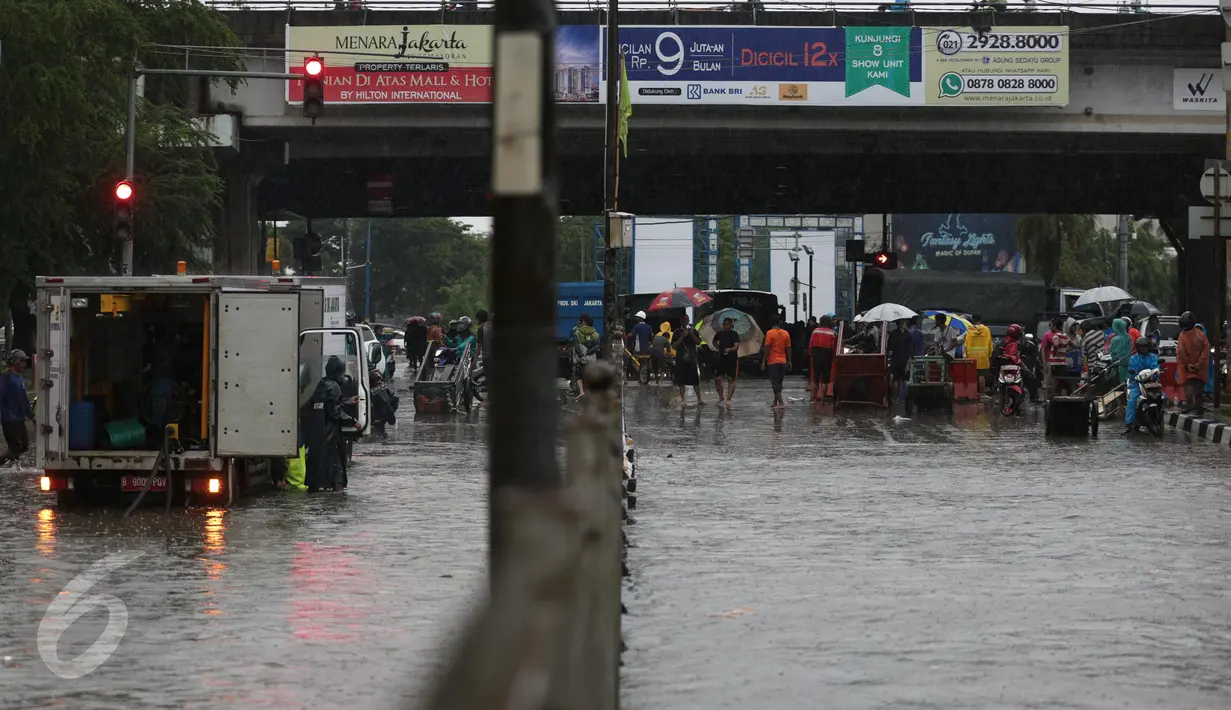 Hujan yang turun sejak dini hari menyebabkan Jalan Gunung Sahari, Jakarta Pusat, terendam banjir, Selasa (21/2). Banjir setinggi pinggang orang dewasa menyebabkan terputusnya sejumlah akses jalan untuk kendaraan bermotor. (Liputan6.com/Faizal Fanani)