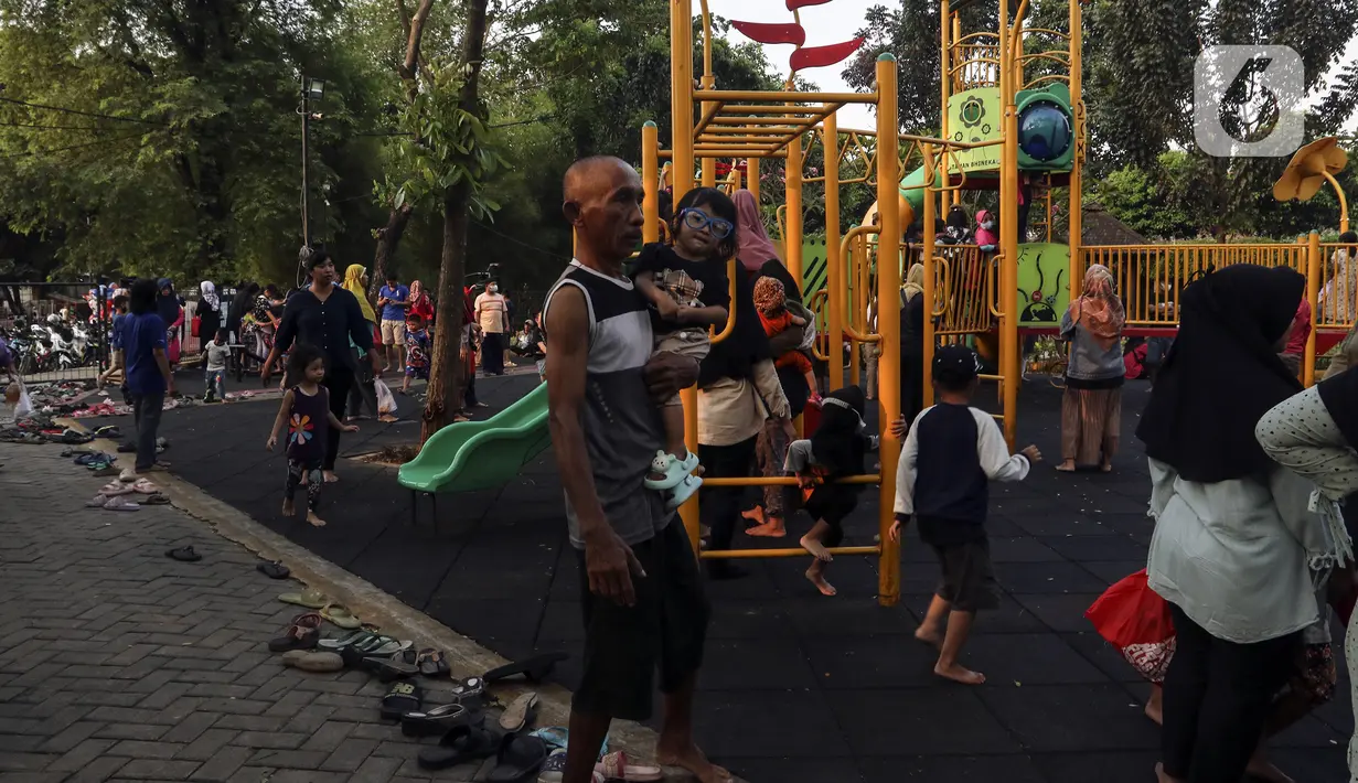 Anak-anak didampingi orangtua bermain di RPTRA Bhineka Jakarta Selatan, Sabtu (30/7/2022). Selain menjadi alternatif mengisi libur bersama keluraga, taman juga menjadi ruang bagi warga untuk berinteraksi sosial sekaligus mengeduksi anak untuk bermain bersama teman-teman dengan wahana yang tersedia. (Liputan6.com/Johan Tallo)