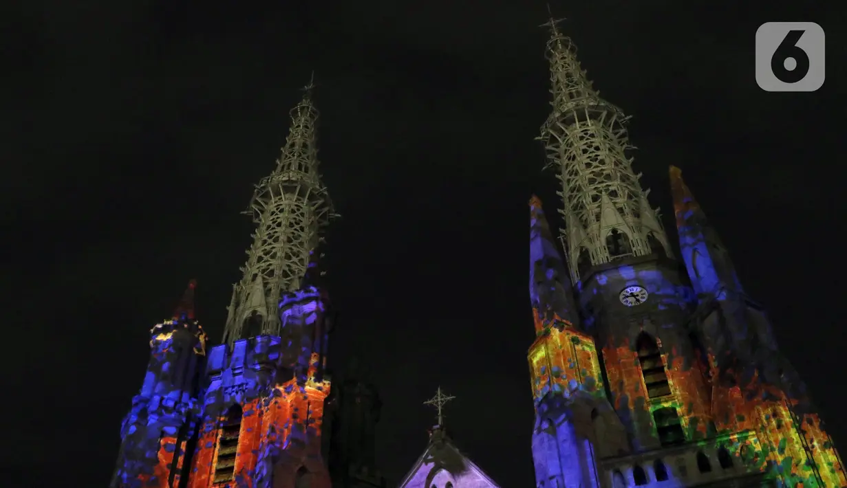Cahaya warna warni menghiasi Gereja Katedral saat pemutaran video mapping tentang sejarah Kongres Pemuda II , Jakarta, Minggu (27/12/2019). Pemutaran video mapping ini untuk memperingati Hari Sumpah Pemuda ke-91 dan berlangsung hingga 28 Oktober. (Liputan6.com/Helmi Fithriansyah)