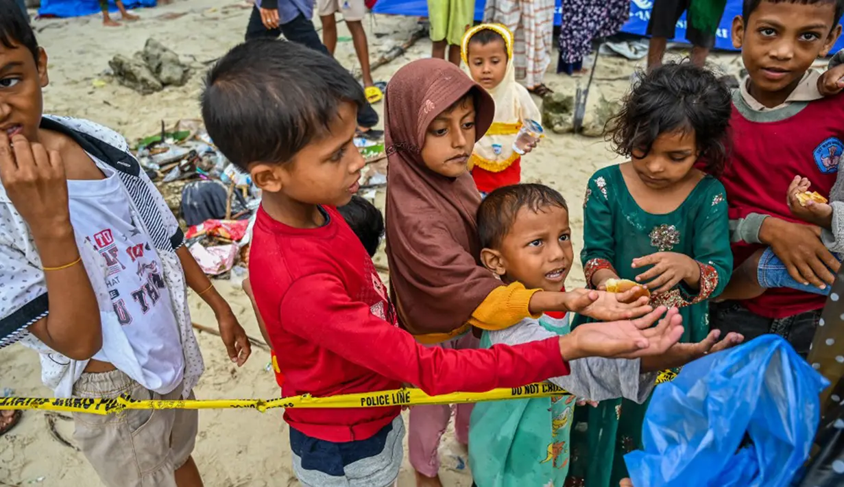Para pengungsi menggunakan perahu kayu yang berbentuk dan berwarna sama dengan sebelumnya. (CHAIDEER MAHYUDDIN/AFP)