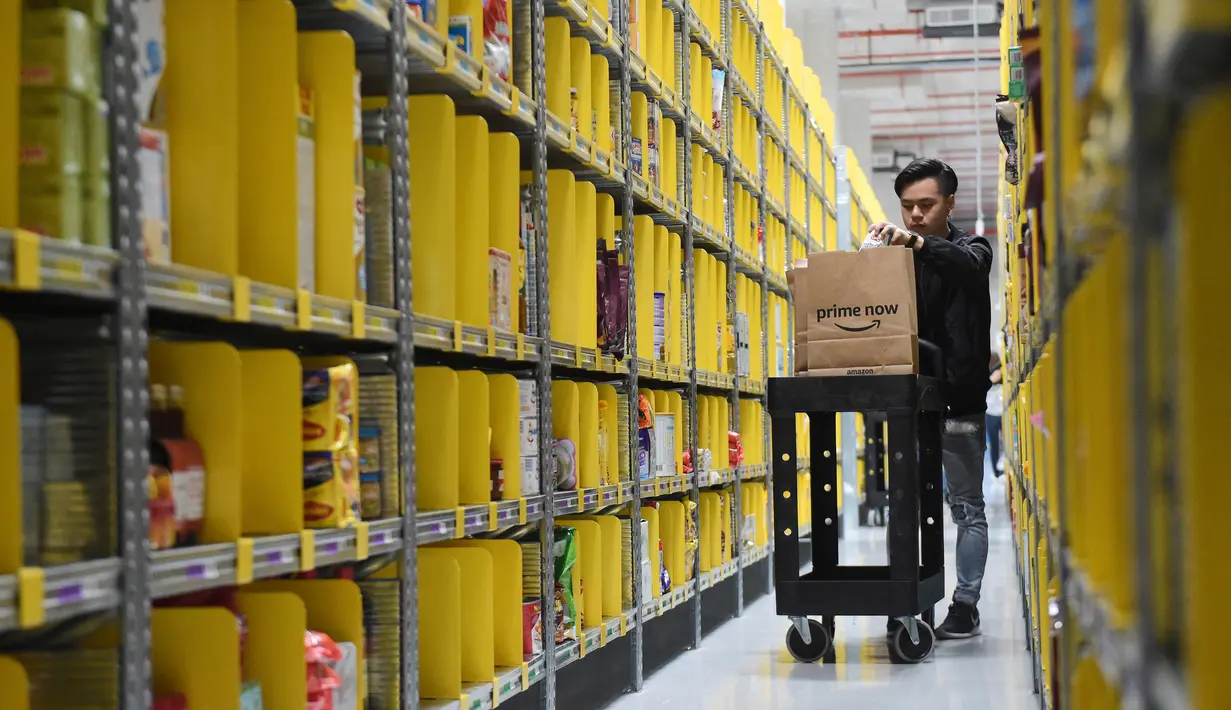 Seorang pekerja mencari barang pesanan milik pelanggan di pusat gudang toko online Amazon usai resmi dibuka di Singapura, Kamis (27/7). Perusahaan yang berdiri sejak 1995 itu kini telah hadir di kawasan Asia Tenggara. (AP Photo/Joseph Nair)