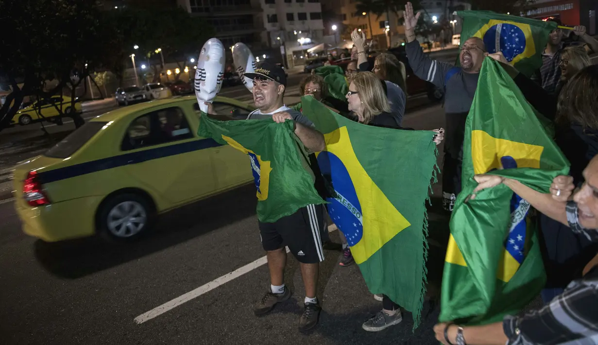 Warga turun ke jalan merayakan keputusan Hakim menjatuhkan hukuman ke mantan Presiden Brasil Luiz Inacio Lula da Silva di Rio de Janeiro, Brasil (12/7). Silva divonis terlibat korupsi dalam perusahaan minyak negara, Petrobras. (AFP Photo/Mauro Pimentel)