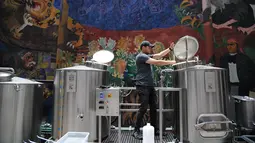 Pekerja mengecek proses pembuatan bir yang botolnya bergambar Presiden AS Donald Trump di perusahaan Cru Cru Brewery di Mexico City (15/6). Meski kontroversial penjualan bir ini sangat cepat laku di tempat tersebut. (AFP Photo/Bernardo Montoya)