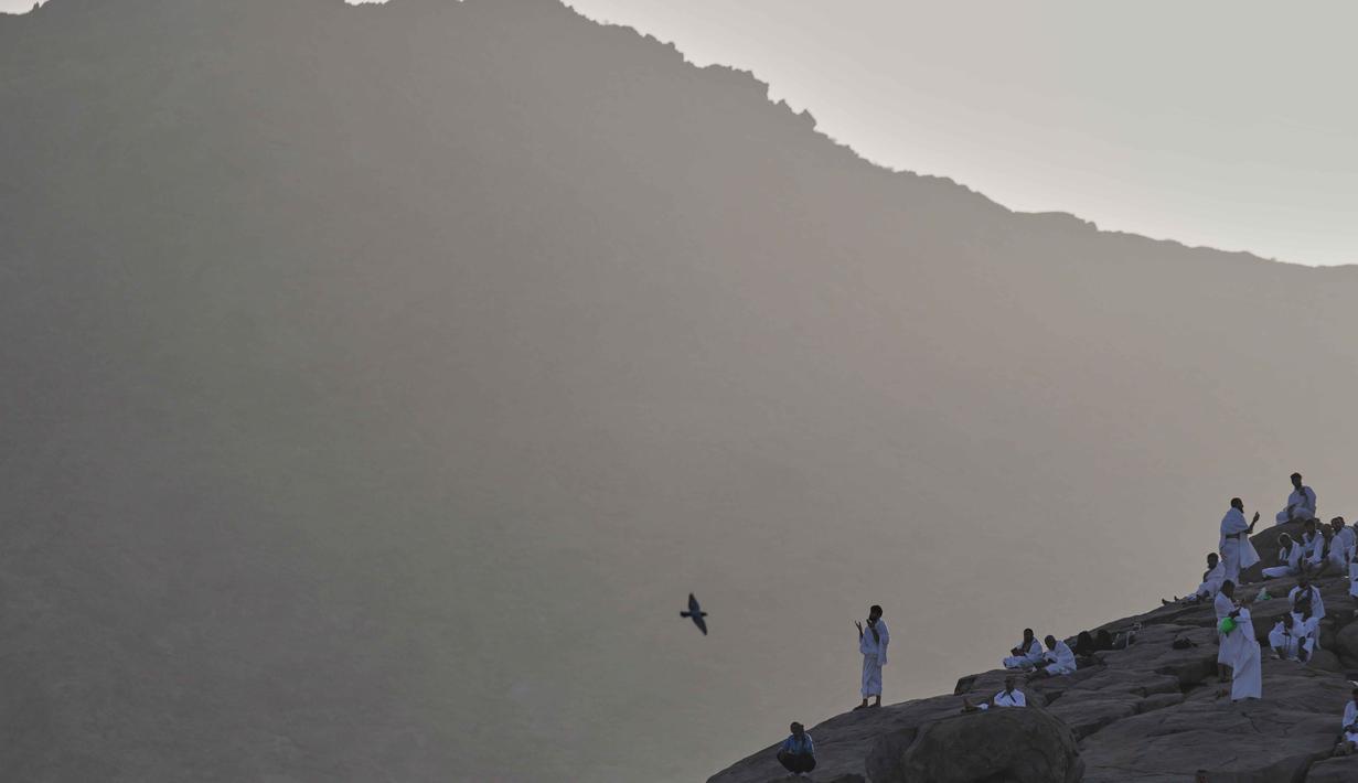 Umat Muslim berdoa di puncak bukit berbatu yang dikenal sebagai Jabal Rahmah atau Gunung Rahmat, di Dataran Arafah, selama ibadah haji tahunan di dekat kota suci Mekah, Arab Saudi, Selasa 26 Mei 2026. (AP Photo/Altaf Qadri)