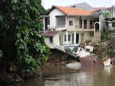Kondisi bangunan rumah yang amblas akibat longsor di bantaran Kali Ciliwung, Kelurahan Bidara Cina, Jakarta Timur, Senin (19/3). Tak ada korban jiwa atau luka dalam musibah yang terjadi pada Minggu dini hari tersebut. (Liputan6.com/Herman Zakharia)