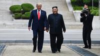 Presiden AS Donald Trump dan Pemimpin Korea Utara Kim Jong-un di sisi utara garis demarkasi militer, zona demiliterisasi Korea (DMZ), Panmunjom pada Minggu 30 Juni 2019 (Brendan Smialowski / AFP PHOTO)