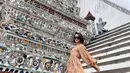 Ririn Ekawati tampil memesona berbalut dress floral warna coklat dengan detail puff sleeve saat berpose di tangga selama liburan di Thailand.  (Instagram/ririnekawati)