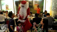 Santa Claus berbincang dengan anak-anak di Bandara Soekarno Hatta, Tangerang, Banten, Selasa (22/12). Sejumlah orang berkostum santa claus membagikan coklat kepada penumpang yang berada dibandara. (Liputan6.com/Faisal R Syam)