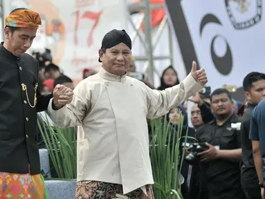 Capres nomor urut 01 dan 02, Joko Widodo (kiri) dan Prabowo Subianto bergandengan tangan saat menuruni panggung Deklarasi Kampanye Damai di Monas, Jakarta, Minggu (23/9). Deklarasi menandai dimulainya masa kampanye Pemilu 2019. (Merdeka.com/Iqbal Nugroho)