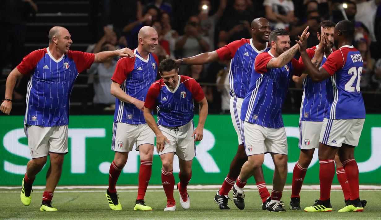 Pemain Prancis 98 merayakan gol yang dicetak Zinedine Zidane saat pertandingan tim Prancis 98 dengan tim FIFA 98 di Arena U, Nanterre, Paris (12/6). Pertandingan ini memperingati 20 tahun kemenangan Prancis di Piala Dunia 1998. (AFP Photo/Thomas Samson)