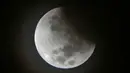 Fenomena gerhana bulan sebagian (parsial) terlihat di langit Jakarta pada Rabu (17/7/2019) dini hari. Gerhana bulan terakhir dalam tahun 2019 ini merupakan fenomena jenis gerhana bulan parsial, karena masih ada yang tampak sebagian. (BAY ISMOYO/AFP)