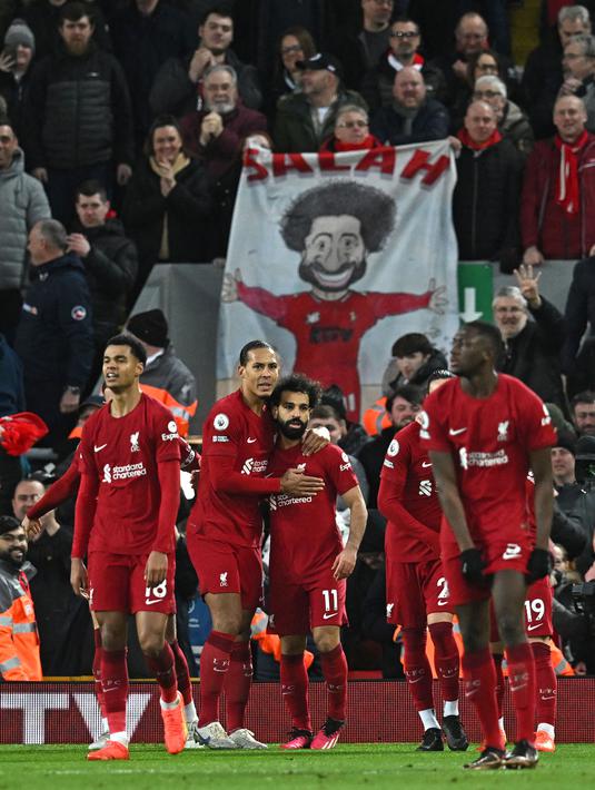 Pemain Liverpool, Mohamed Salah (tengah) melakukan selebrasi bersama rekannya setelah mencetak gol keempat tim ke gawang Manchester United pada laga pekan ke-26 Liga Inggris 2022/2023 yang berlangsung di Anfield, Liverpool, Senin (06/03/2023) WIB. (AFP/Paul Ellis)