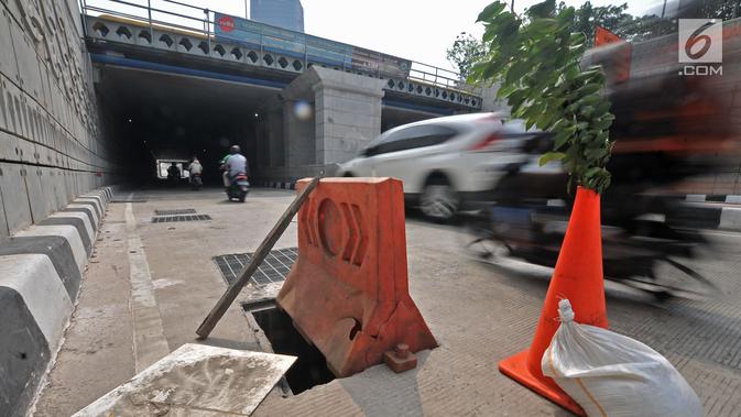 Pembatas jalan berwarna oranye diletakkan dekat penutup lubang saluran air yang hilang di Underpass Mampang-Kuningan, Jakarta, Kamis (23/8). Cone block dan tanaman itu dipasang agar tidak ada pengendara yang kecelakaan. (Merdeka.com/Iqbal S. Nugroho)