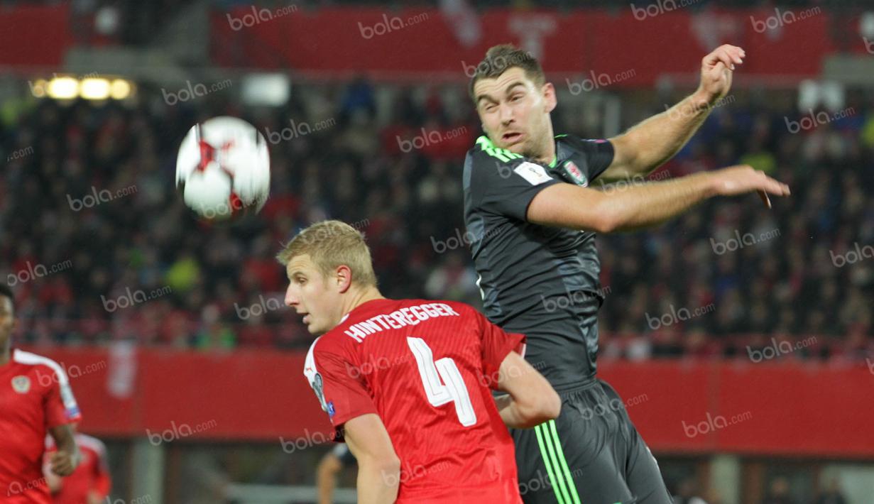 Striker Timnas Wales, Sam Vokes (kanan), berduel dengan bek Austria, Hinteregger. (Bola.com/Reza Khomaini)