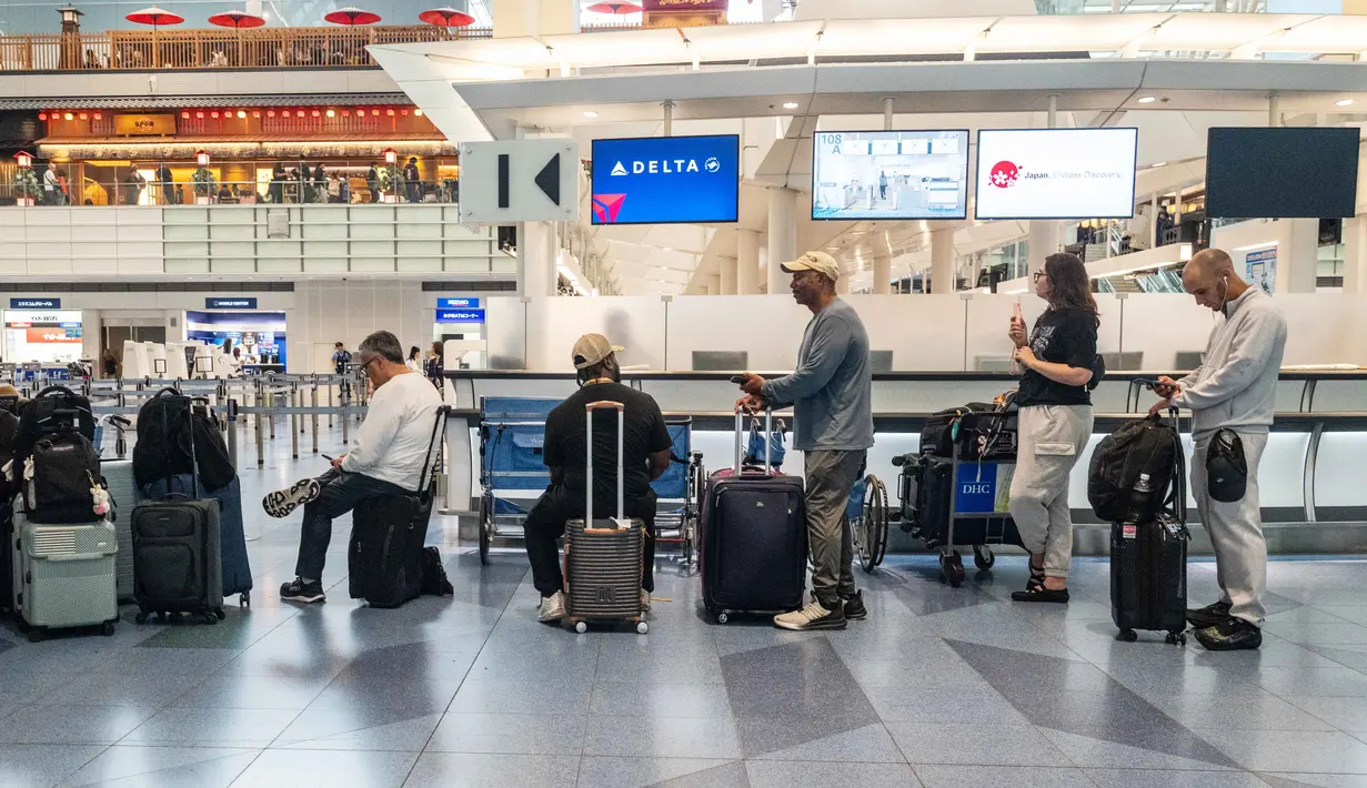 Penumpang menunggu di Terminal Internasional Bandara Haneda setelah penerbangan dibatalkan atau ditunda karena badai tropis Jangmi di Tokyo, Jepang, Rabu 3 Juni 2026. (Andrew CAALLERO-REYNOLDS/AFP)