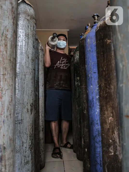 Pekerja membawa tabung oksigen (o2) di agen isi ulang oksigen kawasan Kalimalang, Jakarta, Rabu (27/1/2021). Dalam sehari, warga yang mengisi ulang oksigen mencapai puluhan orang dengan harga Rp25.000 per kubik. (merdeka.com/Iqbal S Nugroho)