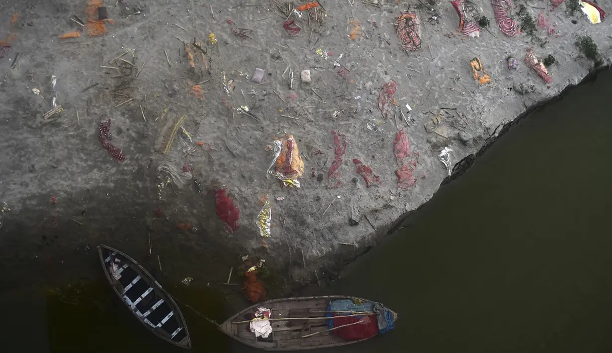 Kuburan dangkal di pasir, beberapa di antaranya diduga orang yang meninggal karena virus corona COVID-19, terlihat dekat tempat kremasi di tepi Sungai Gangga, Phafamau, Allahabad, India, Sabtu (5/6/2021). (SANJAY KANOJIA/AFP)