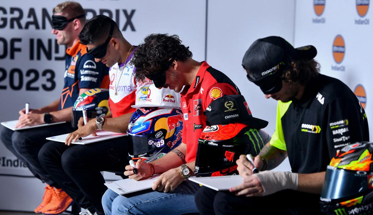 Sejumlah pembalap MotoGP termasuk Francesco Bagnaia (kedua kanan) menggambar Sirkuit Buddh dengan mata tertutup menjelang MotoGP India 2023 pada 21 September 2023. (AFP/Money Sharma)