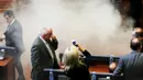 Sejumlah anggota parlemen Kosovo berhamburan saat asap menutupi ruang sidang di Kosovo, Kamis (15/10/2015). Partai oposisi meminta Pemerintah membatalkan kebijakannya, karena dinilai membahayakan integritas Kosovo. (REUTERS/Hazir Reka) 
