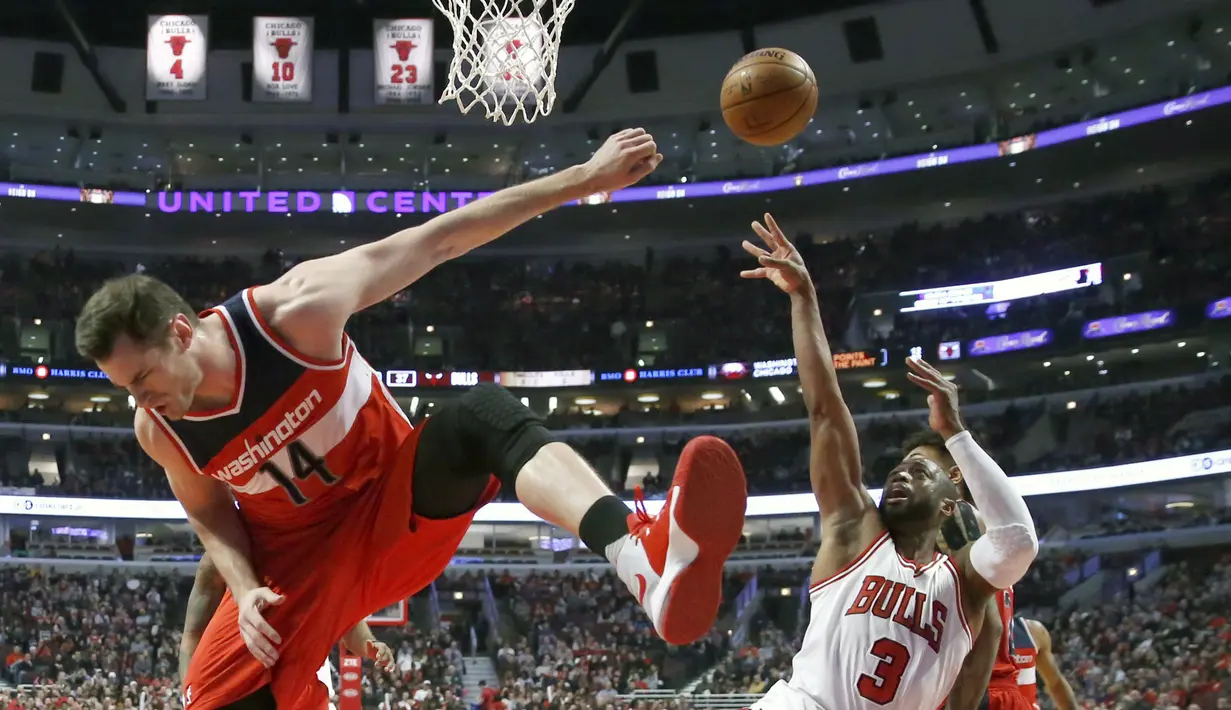 Pemain Chicago Bulls, Dwyane Wade (kanan) melakukan tembakan saat dihadang pemain Washington Wizards, Jason Smith pada laga NBA basketball game di United Center, Chicago, (21/12/2016).  Wizards menang 107-97. (AP/Charles Rex Arbogast)