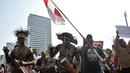 Masyarakat Papua yang merupakan mantan karyawan PT Freeport Indonesia saat melakukan penggalangan dana di tengah berlangsungnya Hari Bebas Kendaraan Bermotor atau Car Free Day di kawasan Bundaran HI, Jakarta, Minggu (5/8). (Merdeka.com/Iqbal S. Nugroho)