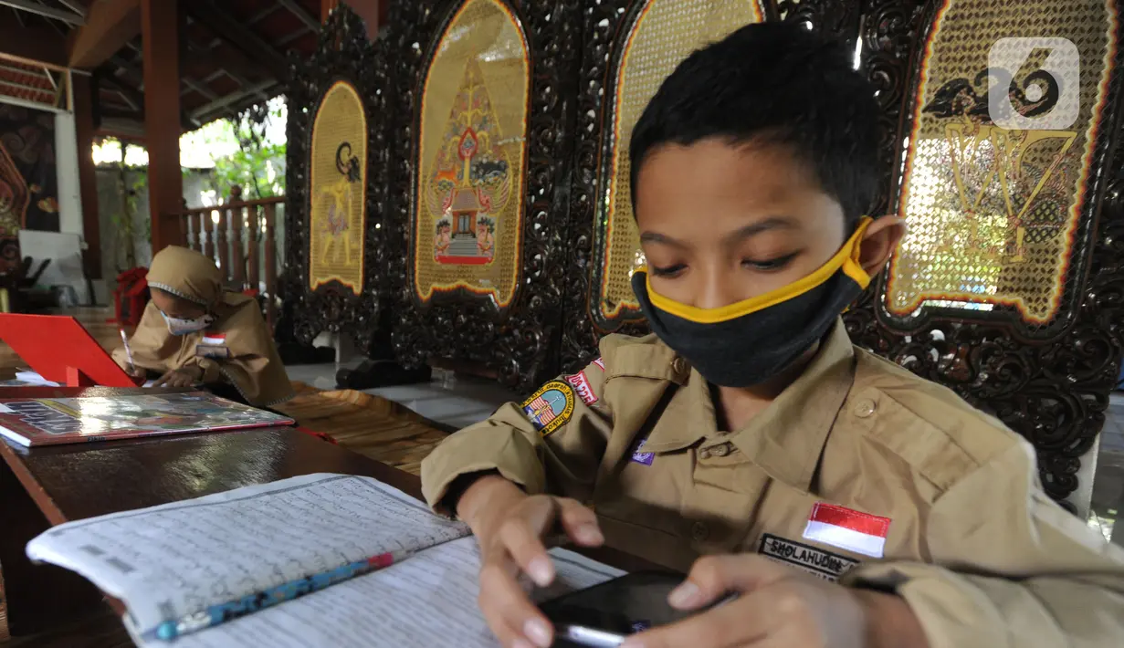 Siswa belajar secara daring menggunakan fasilitas wifi gratis di Perumahan Pondok Mulya I, Beji, Depok, Jawa Barat, Rabu (29/7/2020). Fasilitas tersebut sebagai bentuk kepedulian Sri Wiwoho atas kesulitan warga dalam menyediakan dana belajar daring. (merdeka.com/Arie Basuki)