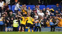 Pemain Wolverhampton Wanderers Conor Coady (ditutupi oleh rekan satu timnya) merayakan setelah mencetak gol ke gawang Chelsea pada pertandingan sepak bola Liga Inggris di Stadion Stamford Bridge, London, Inggris, 7 Mei 2022. Pertandingan berakhir 2-2. (AP Photo/Frank Augstein)