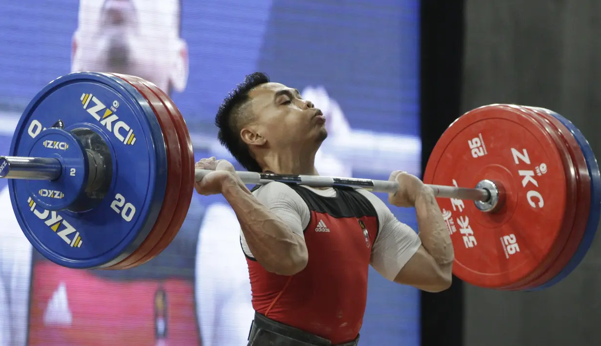 Lifter Eko Yuli melakukan angkatan saat SEA Games 2019 cabang angkat besi nomor 61 kg di Stadion Rizal Memorial, Manila, Minggu (1/12). Dirinya meraih emas dengan total angkatan 309 kg. (Bola.com/M Iqbal Ichsan)