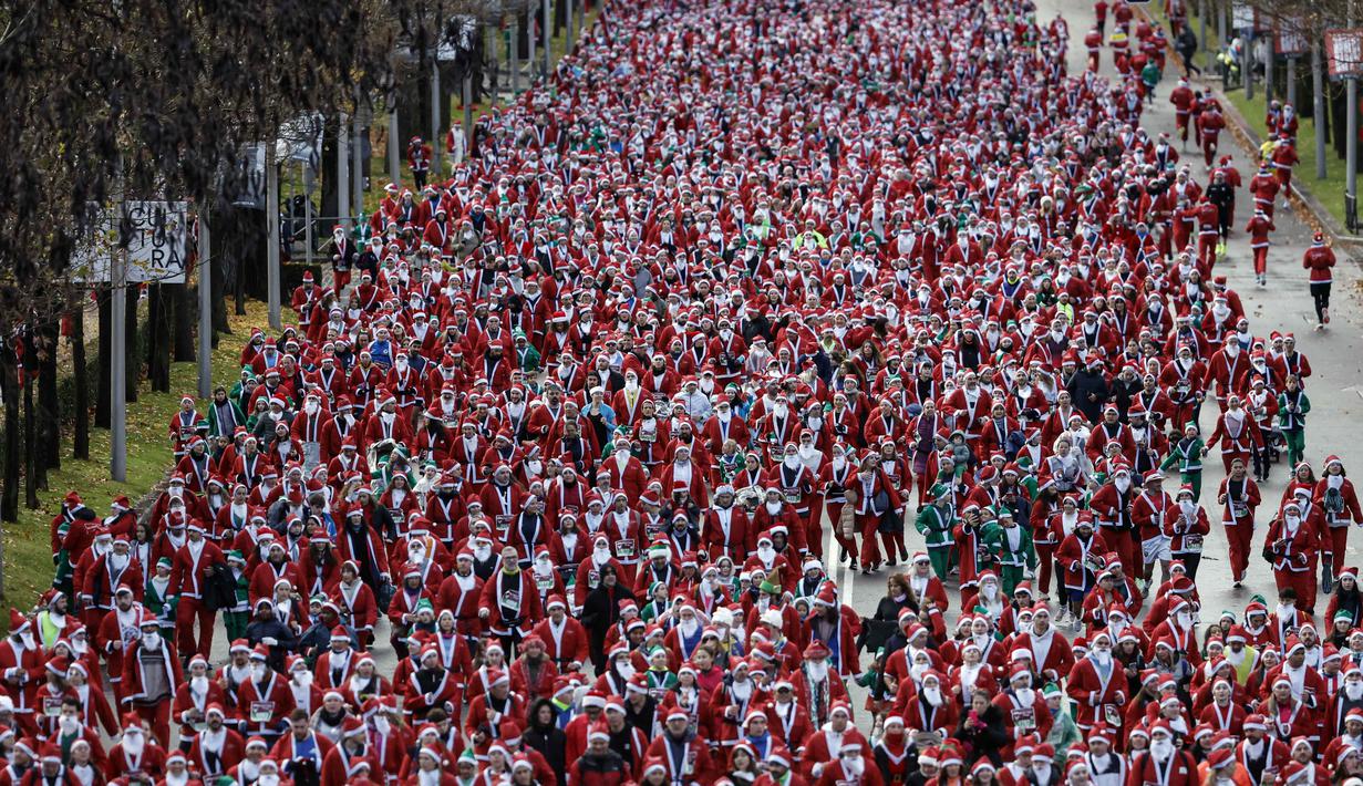Lebih dari 10 ribu orang yang mengenakan kostum Santa Claus, termasuk anak-anak, ikut serta dalam lomba lari sejauh 4,5 kilometer. Tampak dalam foto, ribuan pelari yang mengenakan kostum Santa Claus berpartisipasi dalam edisi ke-14 lomba Santa Claus, sebuah lari santai sejauh 4,5 km melalui jalan-jalan Madrid pada Minggu 21 Desember 2025. (OSCAR DEL POZO/AFP)
