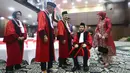 Setelah menyelesaikan seluruh rangkaian prosesi purnabakti, Anwar Usman berpamitan dengan para hakim aktif dan berjalan menuju pintu keluar. Tampak dalam foto, Anwar Usman (kedua kanan duduk) beristirahat usai mengikuti prosesi wisuda purnabakti di Ruang Sidang Mahkamah Konstitusi (MK), Jakarta, Senin (13/4/2026). (Kapanlagi.com/Budy Santoso)