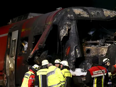 Petugas pemadam mencari masinis yang hilang usai sebuah kereta bertabrakan dengan truk milter di persimpangan kereta api di Freihung, Jerman, Kamis (5/11). Sedikitnya satu orang tewas dan beberapa lainnya terluka. (REUTERS / Michaela Rehle)