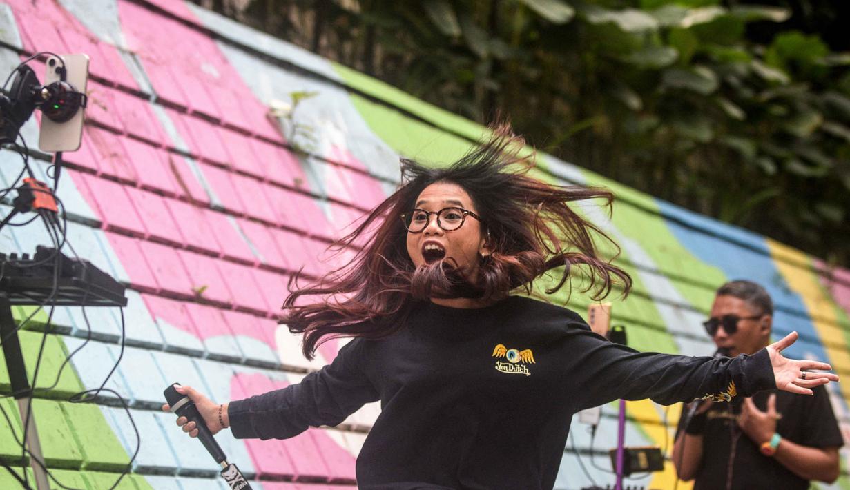 Melalui sarana live streaming, penyanyi bisa mendapat apresiasi finansial langsung dari penonton yang menjadi sumber pendapatan. Tampak dalam foto, para penyanyi dalam jaringan (daring/online) menggunakan dinding berwarna-warni sebagai latar belakang tampil untuk menarik penonton agar memberikan donasi digital selama siaran langsung mereka di situs media sosial, Bandung, Jawa Barat, pada Jumat 8 Mei 2026. (Timur Matahari/AFP)