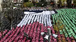 Menurut laporan Anadolu Agency, pada acara yang diselenggarakan di Kota Guernica, orang-orang membuat mosaik dengan rantai manusia yang menggambarkan penderitaan para korban serangan Israel di Gaza dan bendera Palestina. (ANDER GILLENEA/AFP)