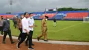 Ketika melihat langsung tribune selatan dan jalan akses keluar-masuk dari lokasi itu, Jokowi berkomentar soal kondisi yang tak ideal di sana. Ia berkomentar soal curamnya tribune tersebut. Selain itu, ia juga berkomentar soal sempitnya jalan akses keluar masuk ke tribune. (AFP/Handout/Indonesia Presidential Palace)