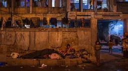 Seorang perempuan tua tinggal di trotoar di luar tempat penampungan bobrok untuk para tunawisma pada malam musim dingin di New Delhi, 28 Desember 2022. 195 tempat penampungan tunawisma di New Delhi hanya dapat menampung sekitar 19.000 orang, membuat puluhan ribu orang berjuang untuk tetap hangat. (AP Photo/Altaf Qadri)