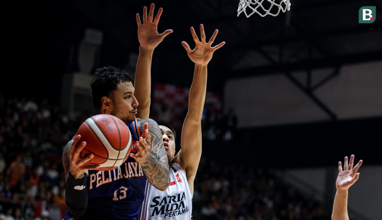 Pemain Pelita Jaya, Brandon Jawato (kiri) malakukan lay up pada gim ketiga final IBL All Indonesia 2024 melawan Satria Muda yang berlangsung di Hall Basket, Senayan, Jakarta, Sabtu (07/10/2024). (Bola.com/Bagaskara Lazuardi)