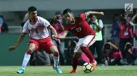 Gelandang Indonesia U-23, Septian David Maulana (kanan) berebut bola dengan bek Bahrain, Sayed Mohamed Shubbar pada laga PSSI Anniversary 2018 di Stadion Pakansari, Kab Bogor, Jumat (27/4). Indonesia kalah 0-1. (Liputan6.com/Helmi Fithriansyah)