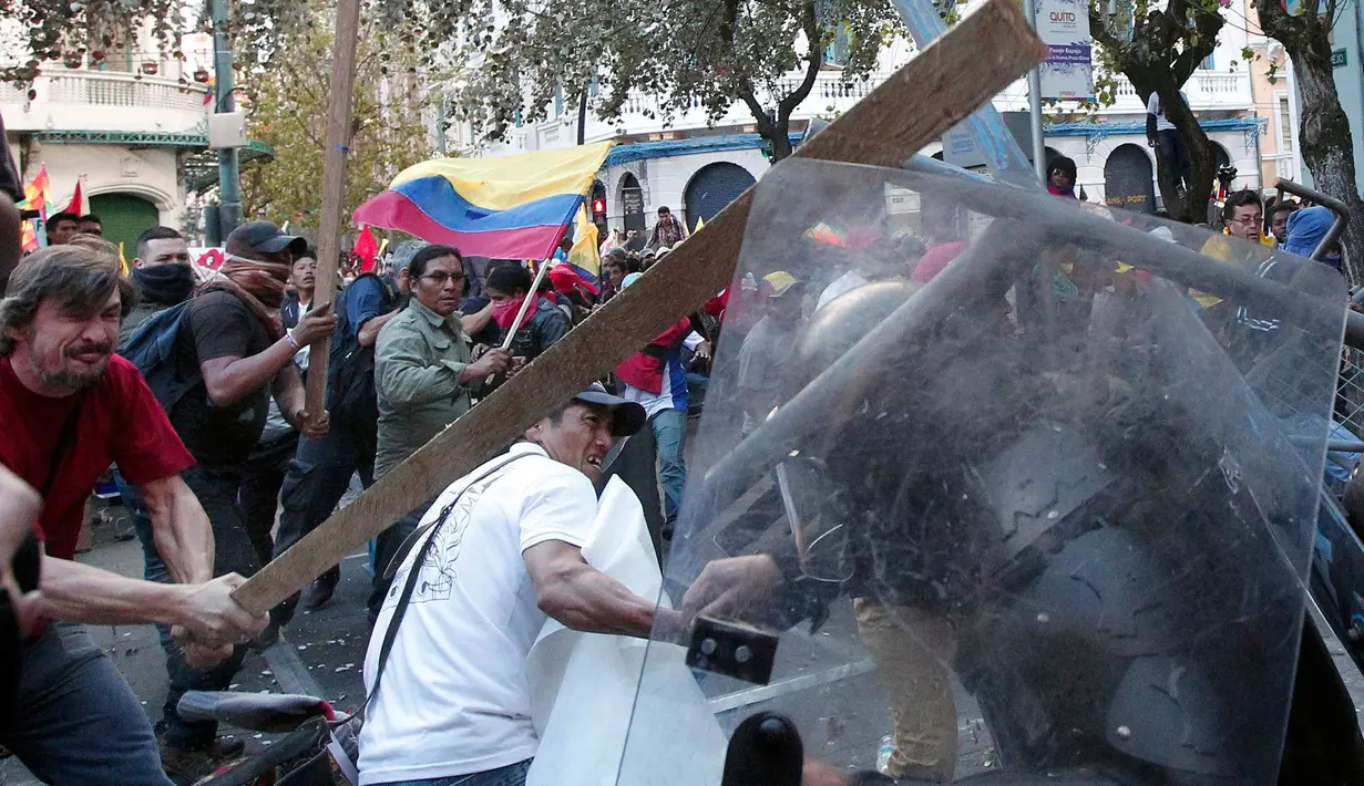 Warga  membawa balok kayu saat bentrok dengan polisi di Quito, Ekuador, Kamis (13/8/2015). Puluhan warga dan aktivis protes rencana Presiden Ekuador, Rafael Correa yang akan menaikan pajak dan pengulangan pemilu. (REUTERS/Guillermo Granja)