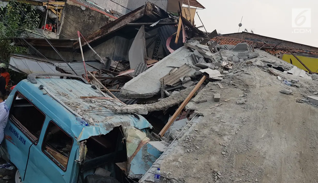 Sebuah angkot tertimpa reruntuhan rumah roboh di di  Jalan Pulo, Tanah Tinggi, Johar Baru, Jakarta Pusa, Jumat (26/4). Menurut saksi mata mengatakan rumah tersebut sedang dalam proses pembangunan yang sudah dilakukan selama kurang lebih satu tahun. (Liputan6.com/Herman Zakharia)