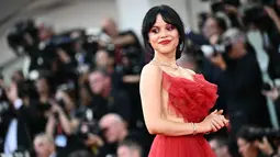 Aktris yang berperan sebagai Astrid Deetz dalam film ini, terlihat sangat sensasional dengan ansambel tipis yang menonjolkan bagian dada yang mengacak-acak, tali bahu yang tipis, dan desain backless. (Marco BERTORELLO / AFP)