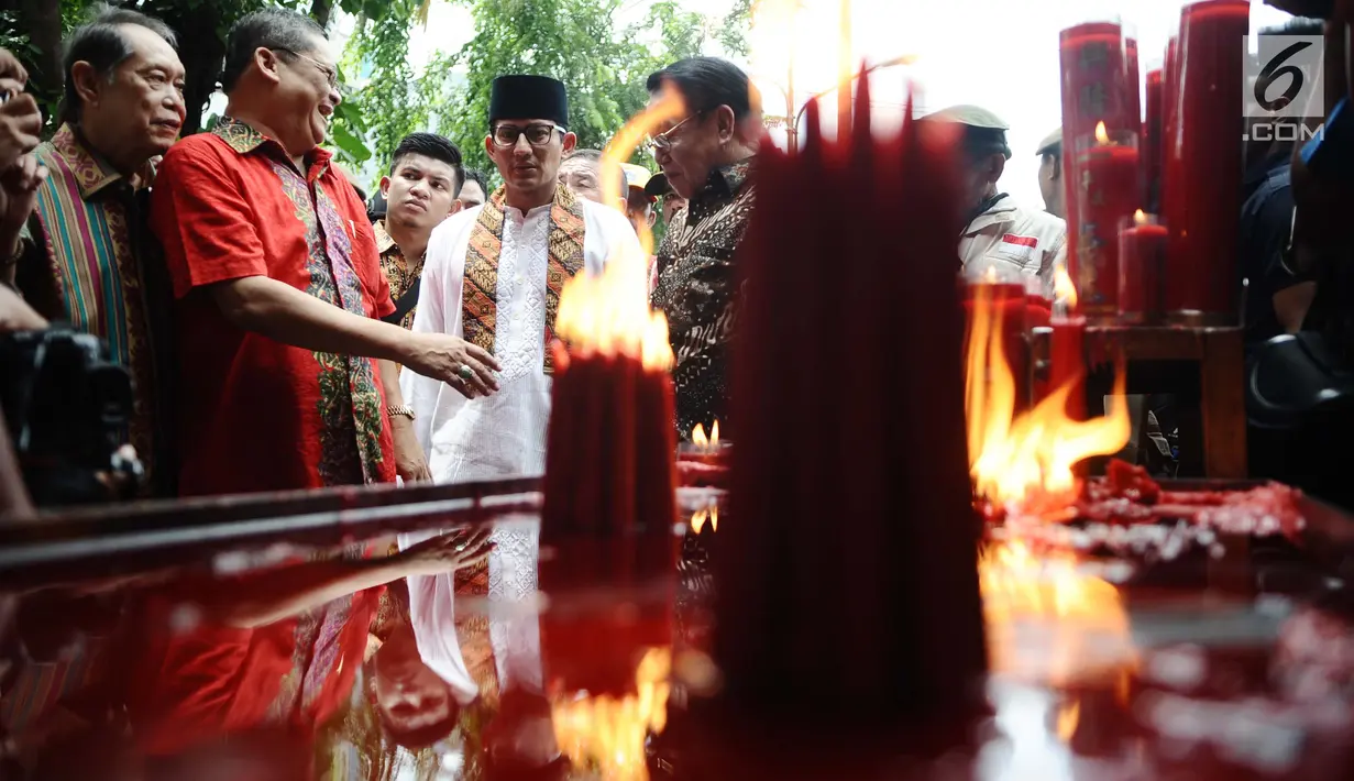Wakil Gubernur DKI, Sandiaga Uno mengunjungi altar tempat menyimpan lilin besar sebagai perayaan ibadah di Vihara Dharma Bakti, Jakarta Barat, Jumat (16/2). Kehadiran Sandi guna merayakan Imlek bersama masyarakat Tionghoa. (Liputan6.com/Gempur M Surya)