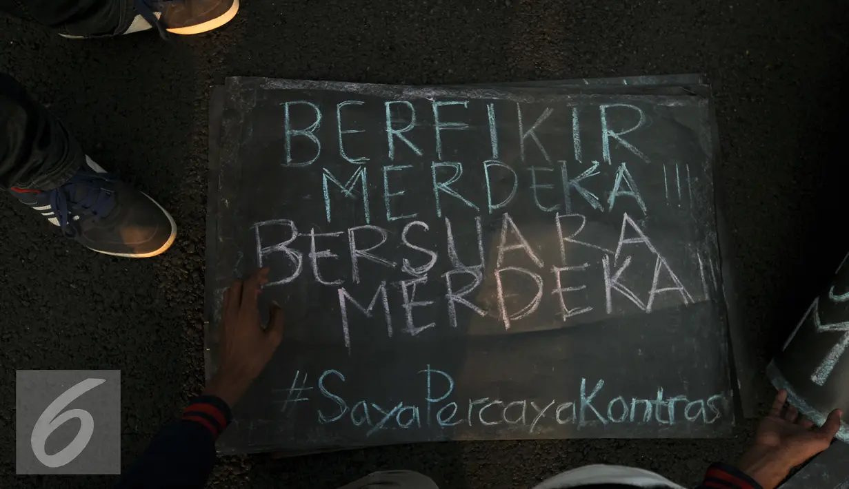 Aktivis meletakkan tulisan saat aksi kamisan di depan Istana Merdeka, Jakarta, Kamis (4/8). Aksi ini juga memberi dukungan buat Koordinator Kontras Haris Azhar yang dituduh melakukan pencemaran nama baik sejumlah lembaga. (Liputan6.com/Helmi Fithriansyah)