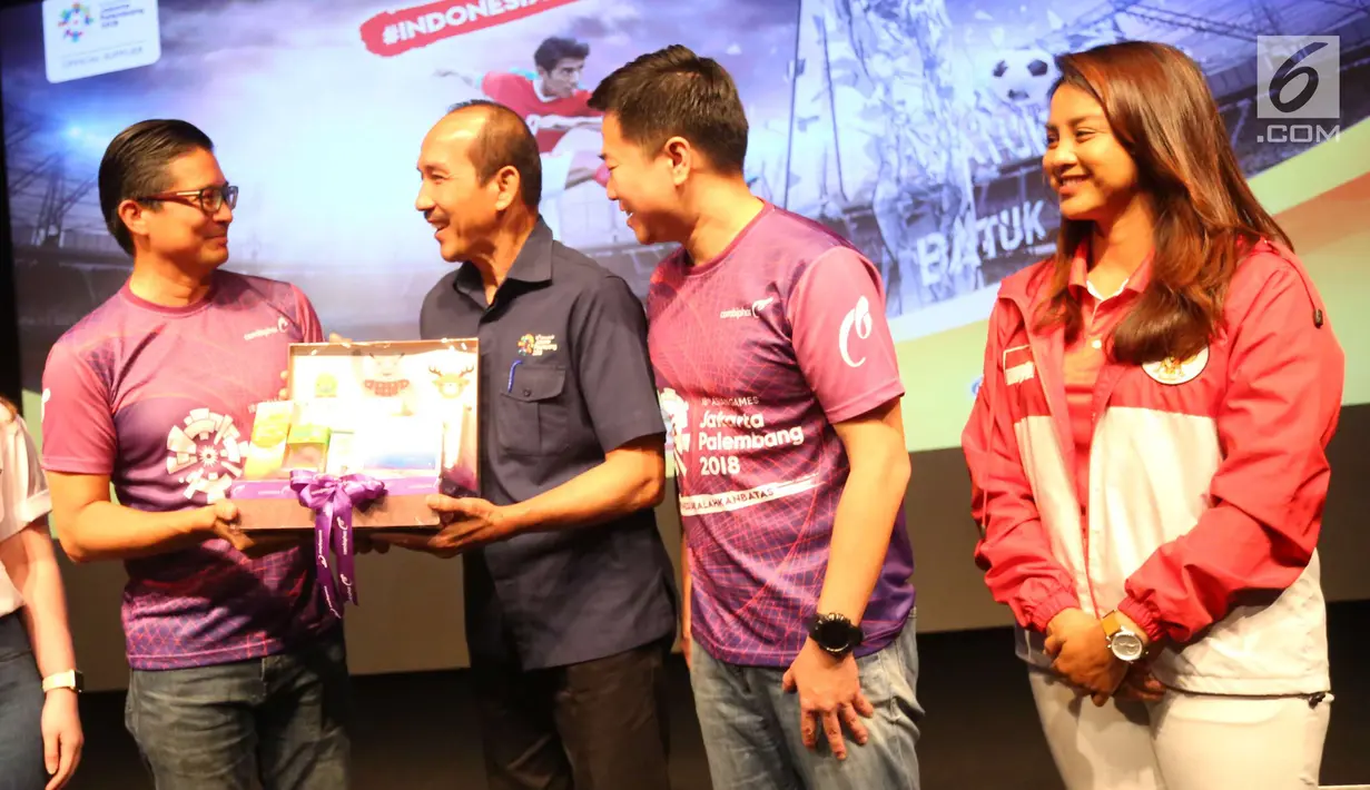 Presdir Combiphar Michael Wanandi memberi cenderamata ke Direktur Revenue INASGOC Hasani Abdulgani saat Kick Off Kampanye #IndonesiaKalahkanBatas di Jakarta, Selasa (24/7). (Liputan6.com/Angga Yuniar)