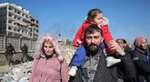 Warga lingkungan Sheikh Maqsud dievakuasi dari zona berbahaya oleh anggota pasukan keamanan pemerintah Suriah, di Aleppo pada Sabtu 10 Januari 2026. Gelombang evakuasi besar-besaran warga sipil dari lingkungan Sheikh Maqsoud dan Ashrafieh di Aleppo, Suriah, terus berlanjut. (OMAR HAJ KADOUR/AFP)