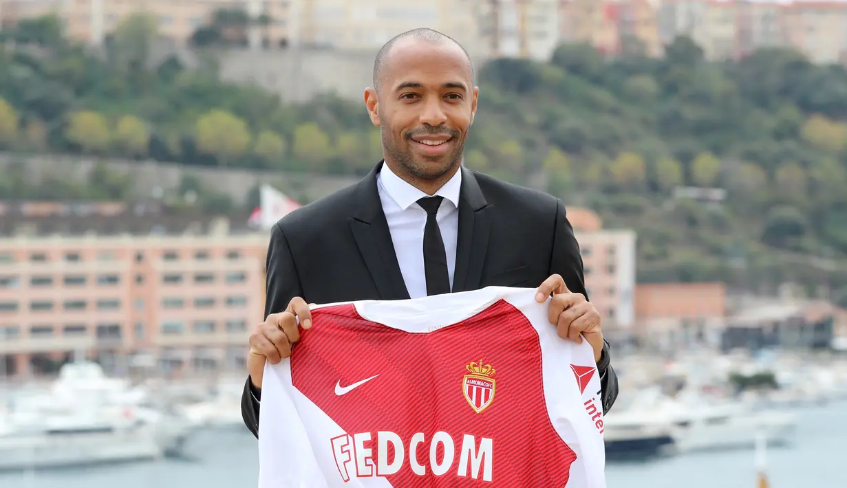 Pelatih AS Monaco, Thierry Henry menunjukkan jersey klubnya saat konferensi pers di Monako, Prancis, Rabu (17/10). Henry resmi melatih AS Monaco menggantikan posisi Leonardo Jardim. (Valery HACHE/AFP)