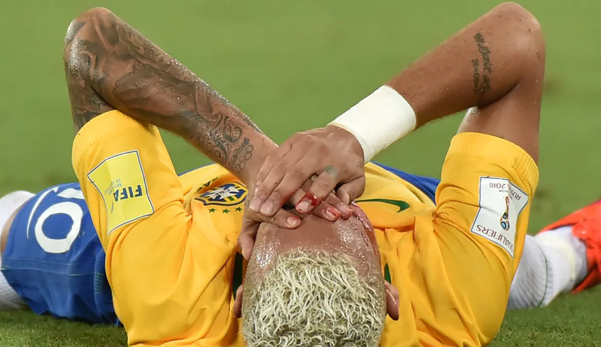 Neymar menutupi wajahnya yang penuh darah saat melawan Bolivia pada kualifikasi Piala Dunia 2018 di Stadion Dunas Arena, Brasil (6/10). Neymar mengalami luka setelah mendapat sikutan keras penyerang Bolivia, Yasmani Duk.  (AFP PHOTO/Nelson Almeida) 