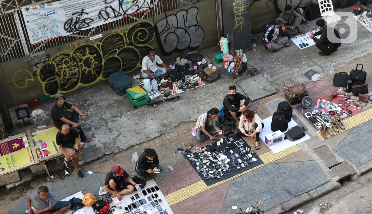 Pedagang kaki lima menjajakan dagangannya di trotoar kawasan Kebayoran Lama, Jakarta, Jumat (15/5/2020). Kondisi ini menyulitkan pejalan kaki yang akan melintasi trotoar di kawasan tersebut. (Liputan6.com/Helmi Fithriansyah)